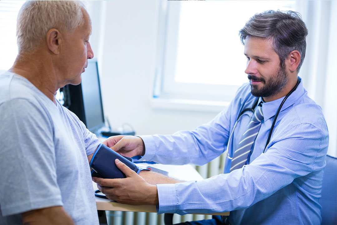 Doctor taking blood pressure of elderly man